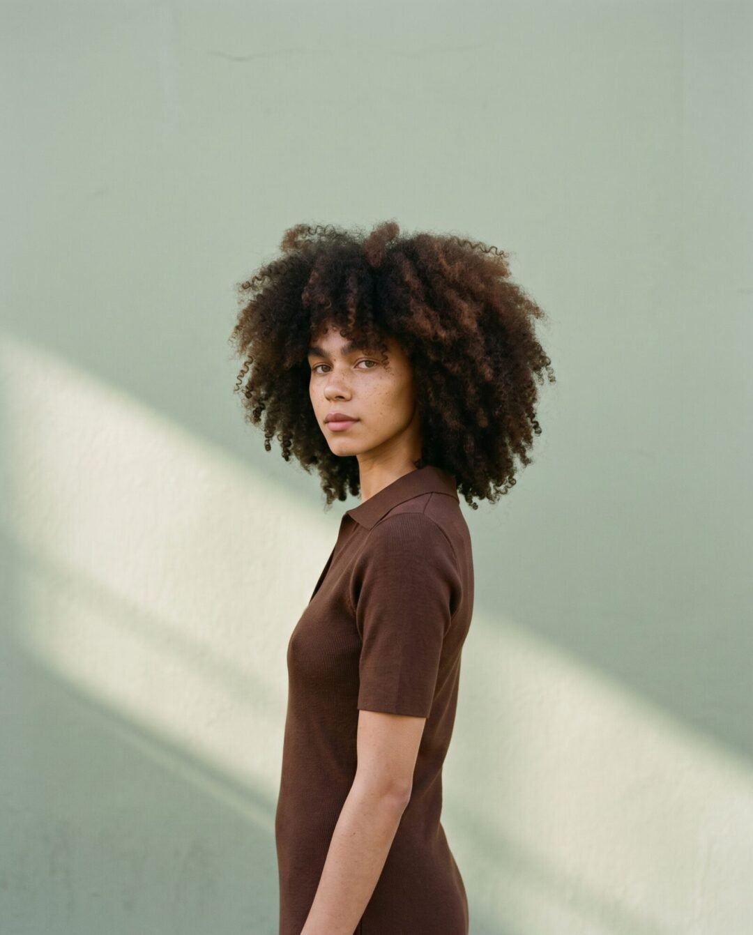 Leah Jacobs against a sage green wall in Bo-Kaap