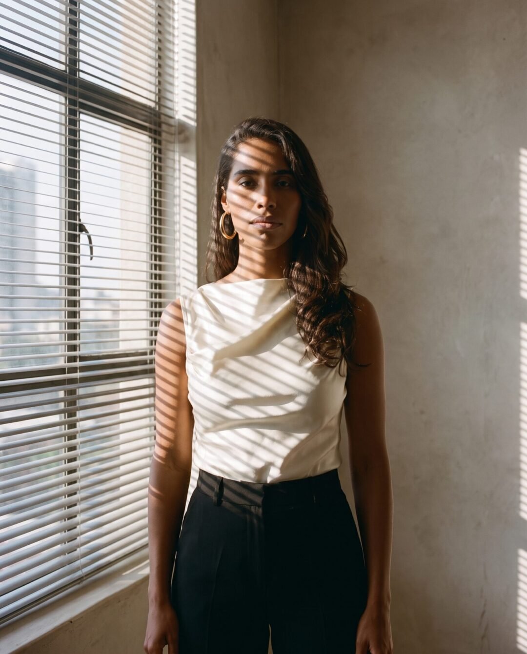 Yasmin Pillay in window light with striped shadows